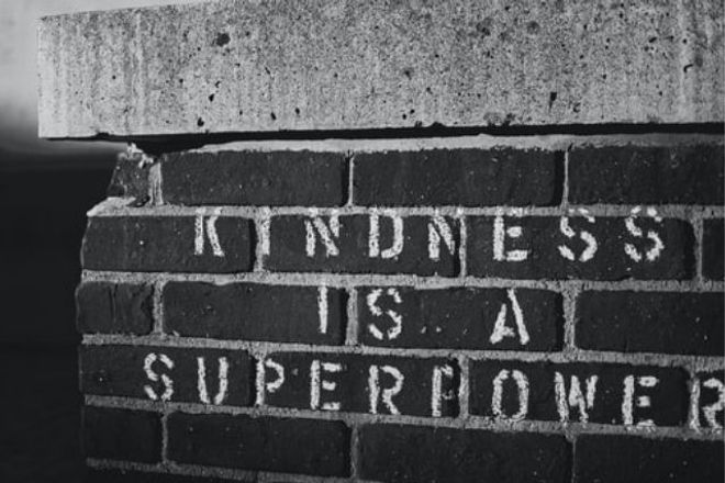 'Kindness is a superpower' stencilled onto bricks (in black and white)