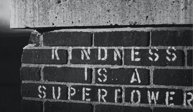'Kindness is a superpower' stencilled onto bricks (in black and white)