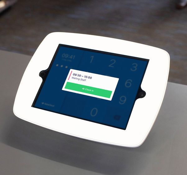 Employee having their photo taken on a clocking in terminal with shift details and 'Clock in' button.