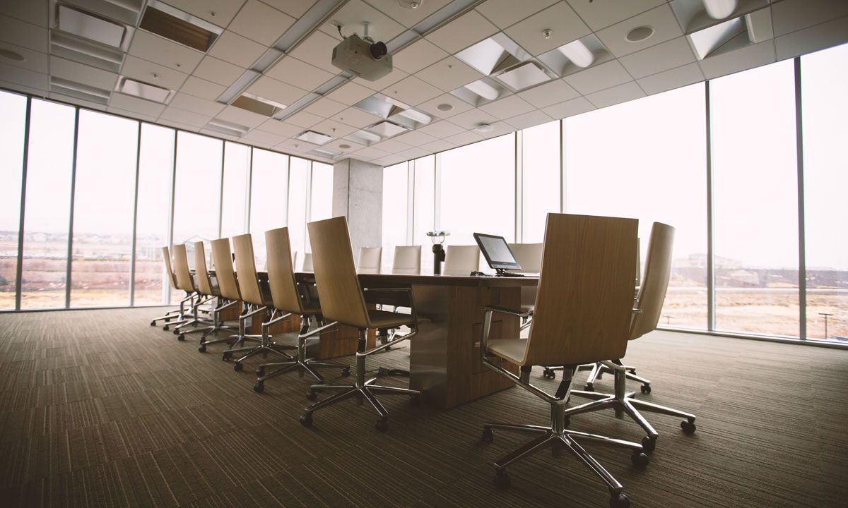 Meeting room in a high-rise office which neatly aligned chairs and a long table 
