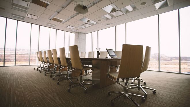 Meeting room in a high-rise office which neatly aligned chairs and a long table 