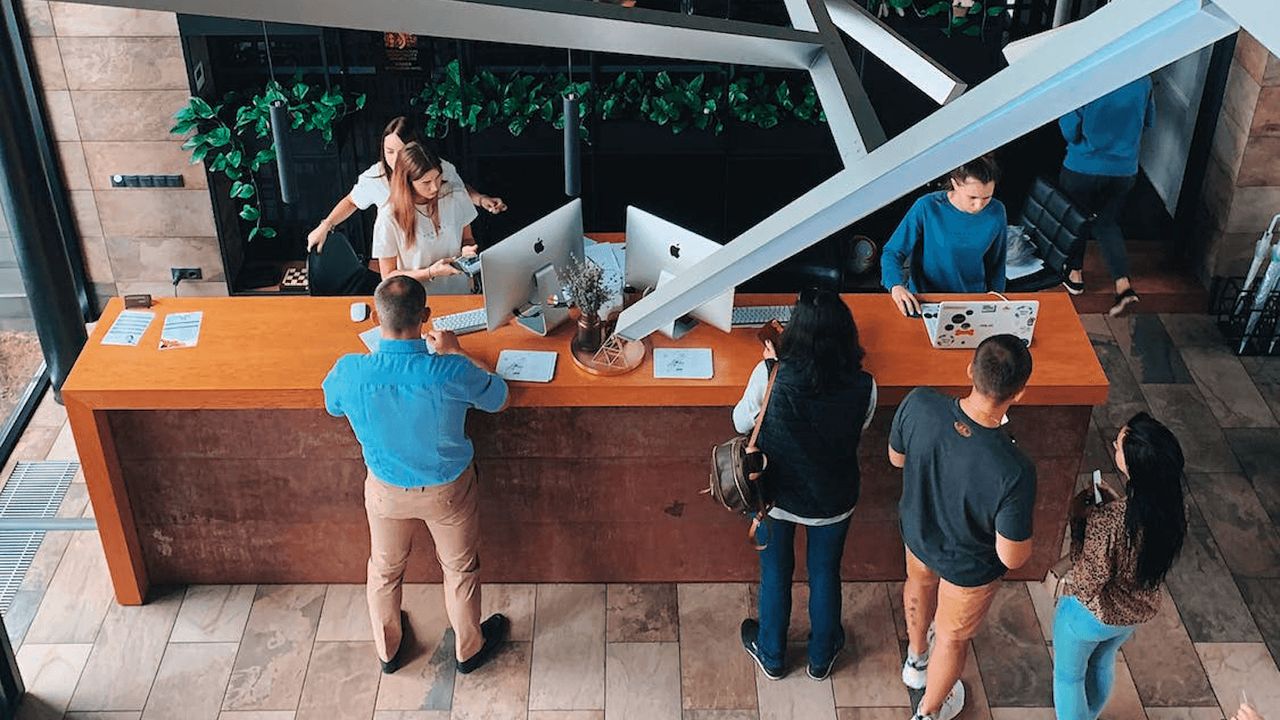 Photo of people checking in at a long hotel reception desk