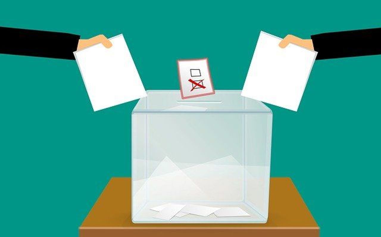 Cartoon illustration of two arms putting white paper cards into a voting box
