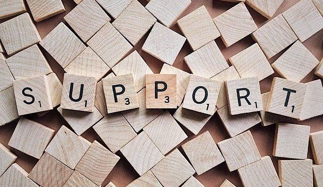 Wooden tiles covering a surface, with some turned over to spell 'support'