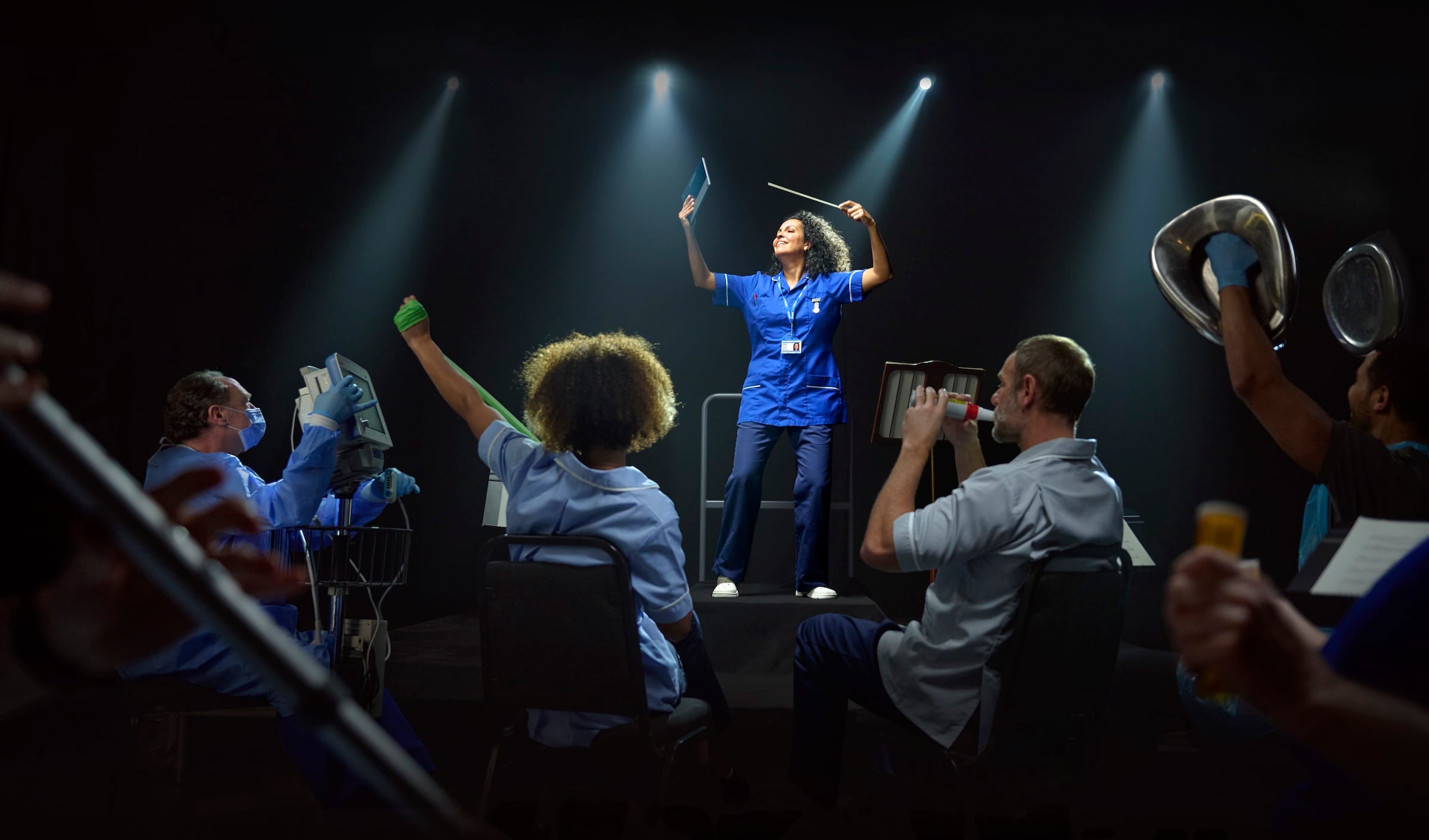 A nurse conducting an orchestra of medical staff holding different equipment