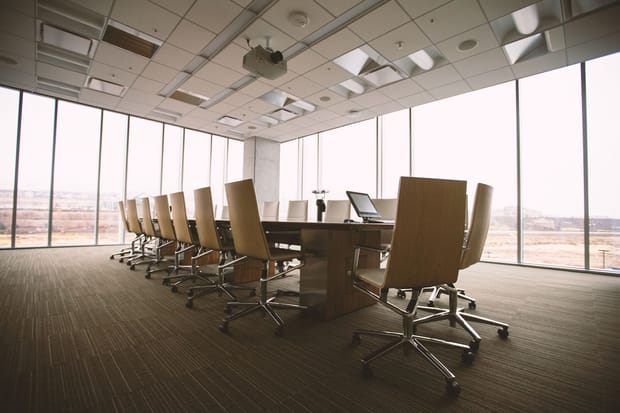 Meeting room in a high-rise office which neatly aligned chairs and a long table 