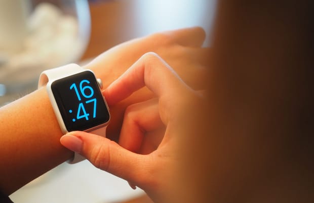 Close up photo of a smartwatch displaying 16:47 on a woman's wrist